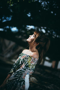 Smiling woman looking away standing in park