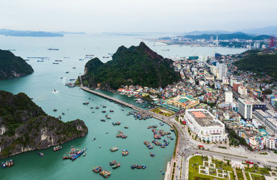 High angle view of town by sea against sky