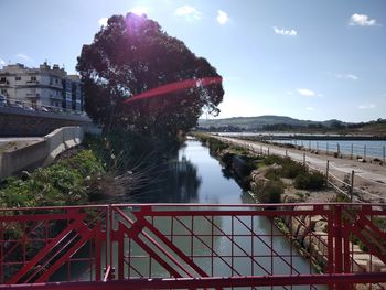 Bridge over river in city against sky