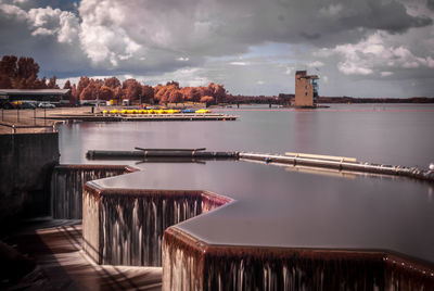 Scenic view of river against sky in city