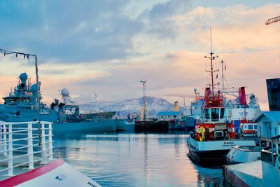 Boats moored at harbor against sky