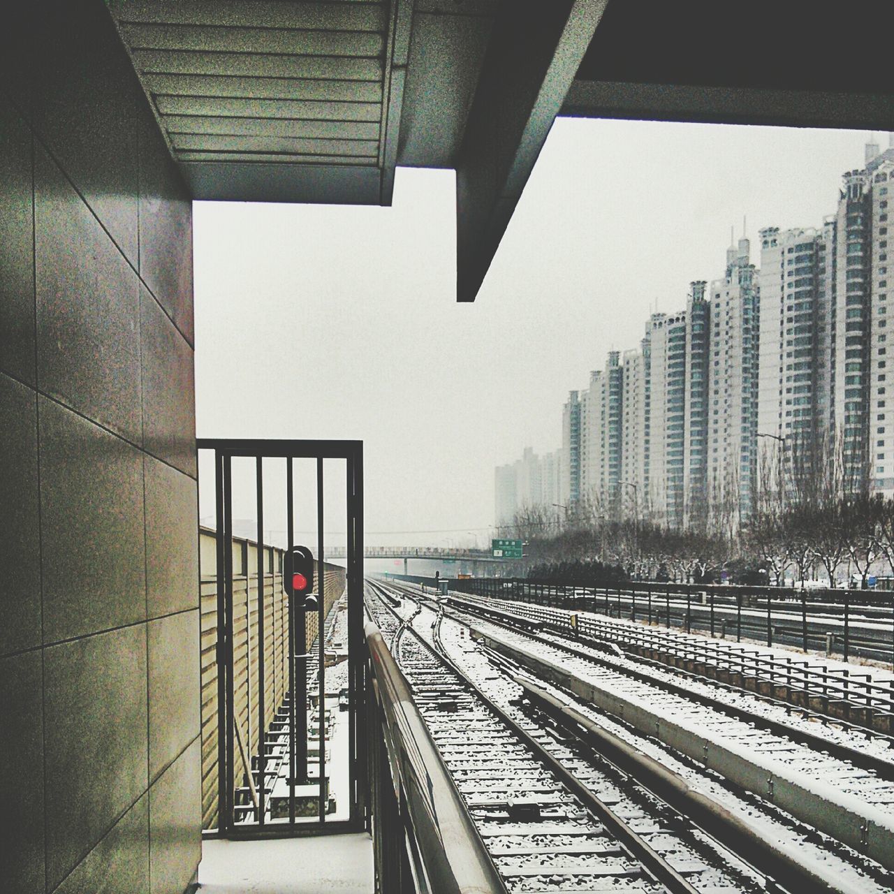 architecture, built structure, clear sky, building exterior, city, the way forward, railing, transportation, modern, city life, railroad track, incidental people, diminishing perspective, railroad station, office building, railroad station platform, building, sunlight, day