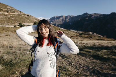 Portrait of smiling young woman standing on mountain