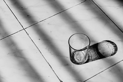 High angle view of glass on tiled floor