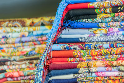 Stack of multi colored shawls for sale at market stall