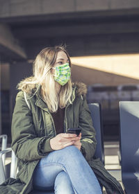 Midsection of man using mobile phone while sitting in bus