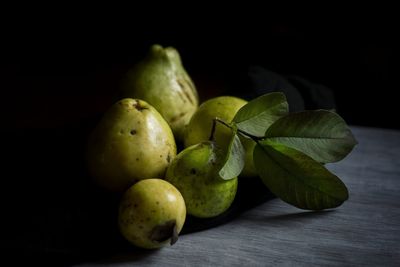 Close-up of fruits on table against black background