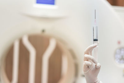 Cropped hand of doctor holding syringe at hospital