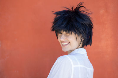 Woman with scruffy hairstyle isolated on red background