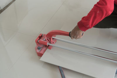 Cropped hand of worker installing tile