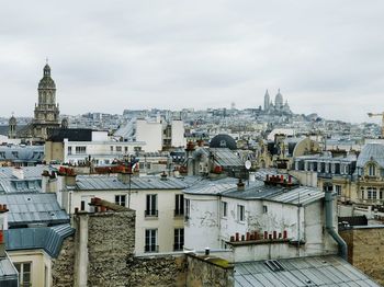 View of cityscape against cloudy sky