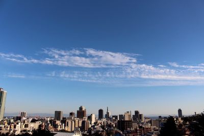 View of cityscape against blue sky