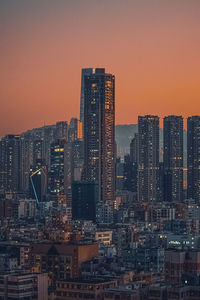 Illuminated buildings against sky during sunset