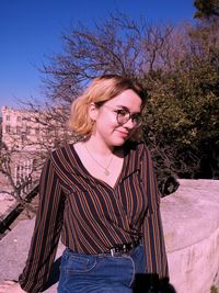 Portrait of woman sitting against plants