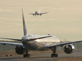 Airplane on airport runway against sky