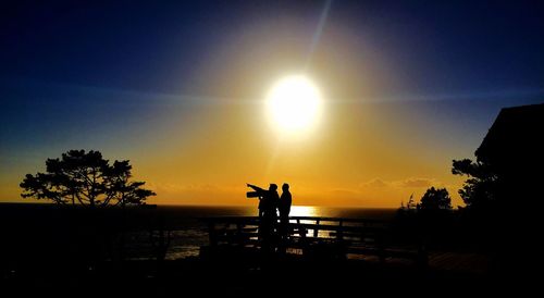 Silhouette of people in water at sunset