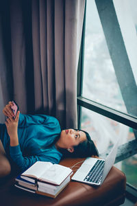 Young woman using mobile phone on table