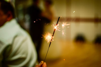 Close-up of hand holding sparkler at night