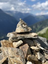 Stack of stones on rock against sky