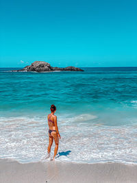  woman on beach against clear blue sky