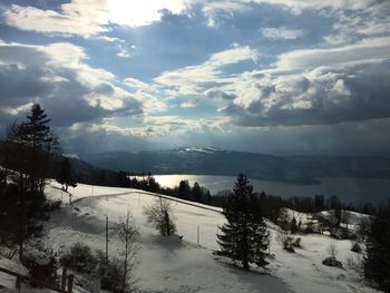 Scenic view of snow covered mountains against cloudy sky