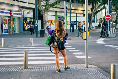 Full length of woman crossing road