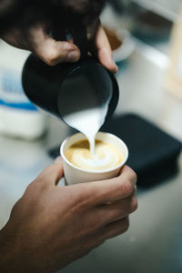 Midsection of man holding coffee cup