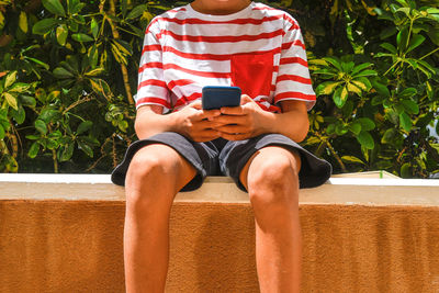 Midsection of man using mobile phone