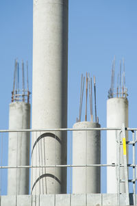 Low angle view of concrete columns at incomplete building against clear sky