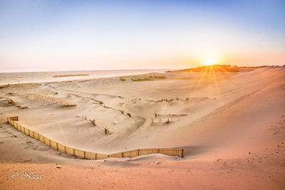 Scenic view of desert against sky during sunset