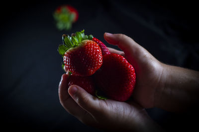 Close-up of hand holding strawberry