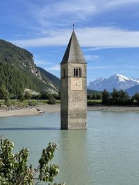 Scenic view of building by mountain against sky