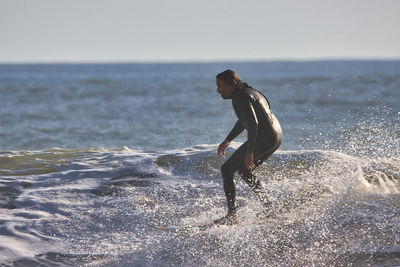 Side view of man on beach against sky