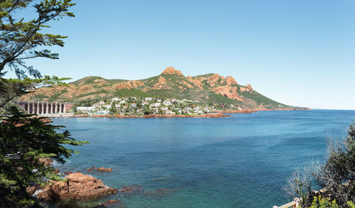 Town by sea against mountains and sky