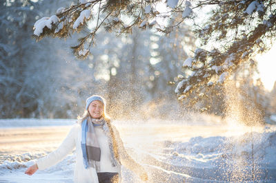 Portrait of young woman standing on snow