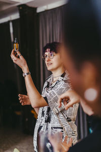 Non-binary person examining essential oil sample during event at convention center