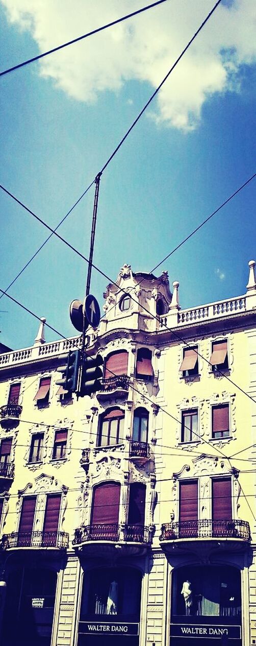 low angle view, power line, architecture, building exterior, built structure, cable, electricity, sky, power supply, power cable, electricity pylon, residential building, street light, connection, building, day, technology, outdoors, residential structure, lighting equipment