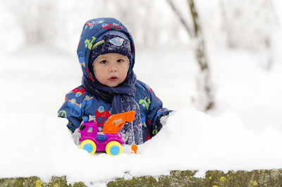 Cute boy looking away on snow field