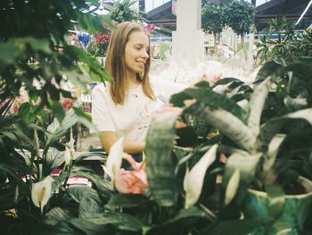 Portrait of smiling woman standing against plants