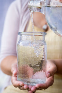 Water being poured into a glass drinking jar