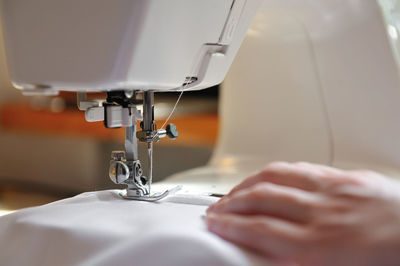 Cropped image of hand sewing on machine