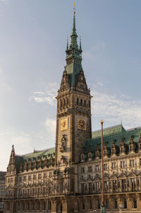 Low angle view of clock tower against sky in city