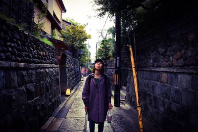 Young woman standing in alley