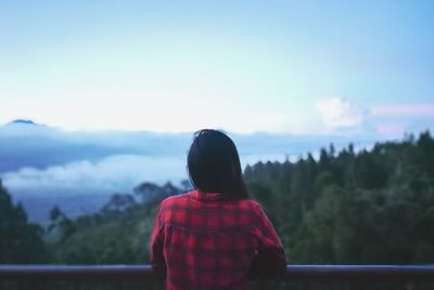 Rear view of woman looking at landscape against sky