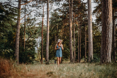 Woman walking on grass in forest