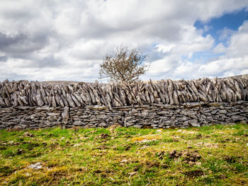 Stack of rocks on field against sky