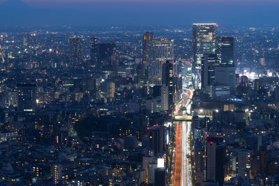 Illuminated cityscape against sky at night