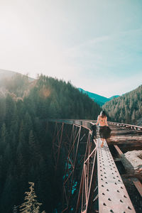 Man standing by bridge against sky