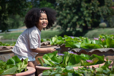 Young woman smiling while sitting on plants