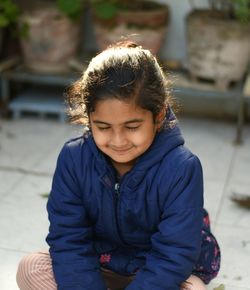 Portrait of a smiling young woman sitting outdoors